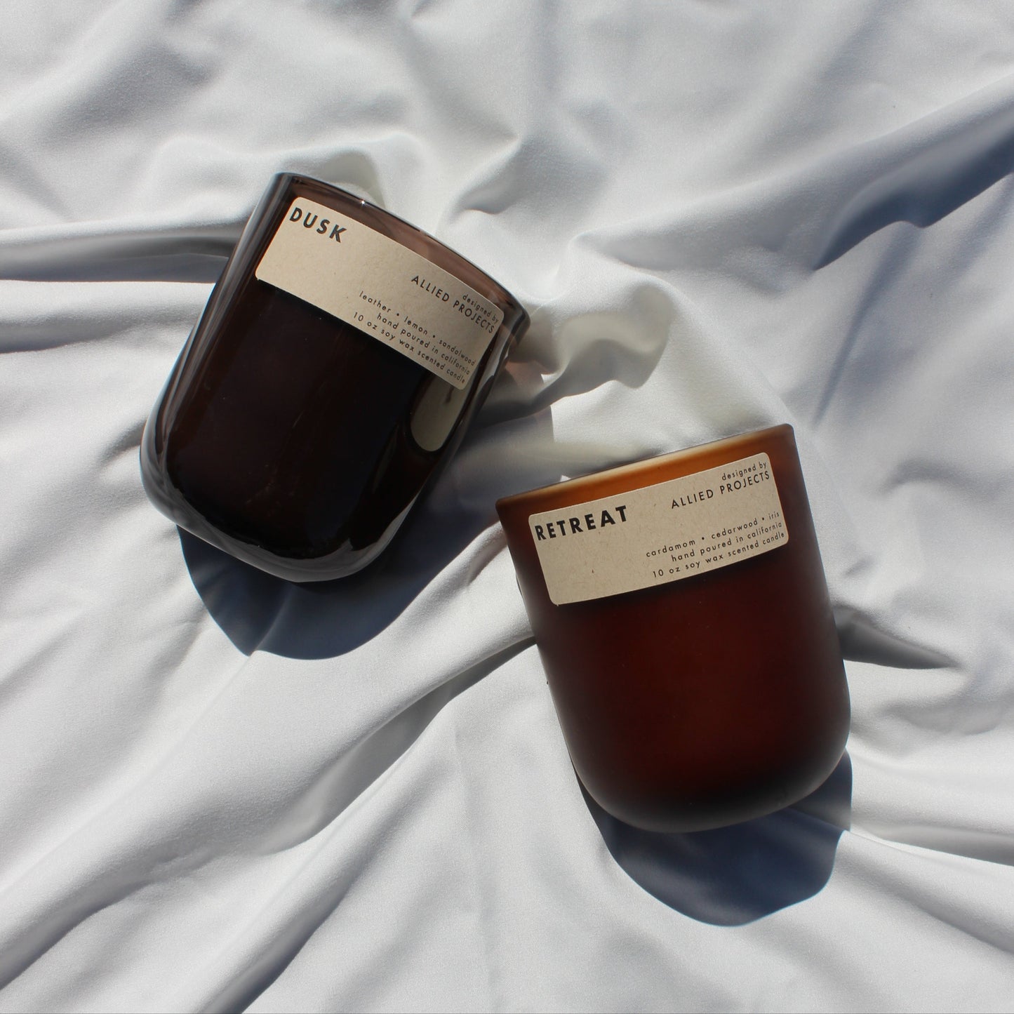 Eco-friendly, hand-poured candles for spring—Retreat and Dusk bring warmth and sophistication to any space. Retreat features a grounding blend of spicy cardamom, rich cedarwood, and delicate iris, while Dusk offers a moody fusion of warm sandalwood, smooth leather, and a refreshing hint of lemon. Made with natural, sustainable wax for a clean, non-toxic burn.