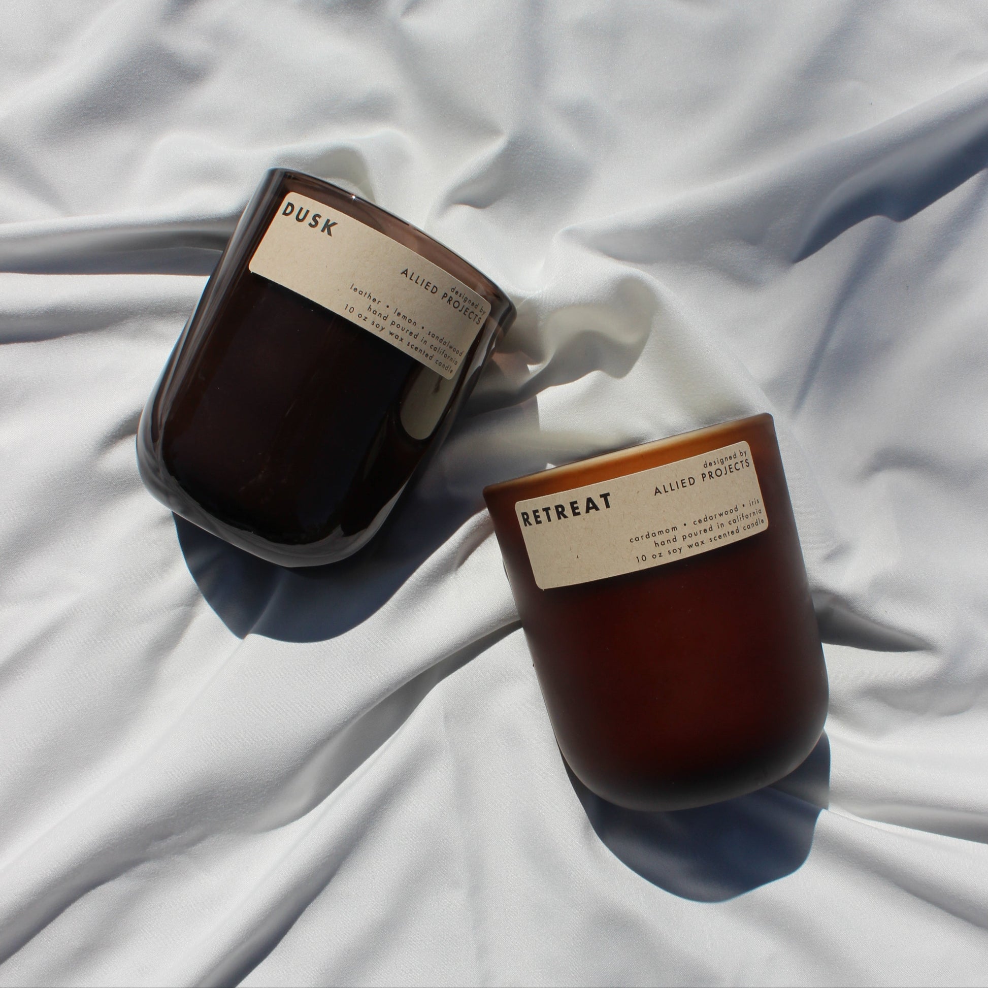 Eco-friendly, hand-poured candles for spring—Retreat and Dusk bring warmth and sophistication to any space. Retreat features a grounding blend of spicy cardamom, rich cedarwood, and delicate iris, while Dusk offers a moody fusion of warm sandalwood, smooth leather, and a refreshing hint of lemon. Made with natural, sustainable wax for a clean, non-toxic burn.